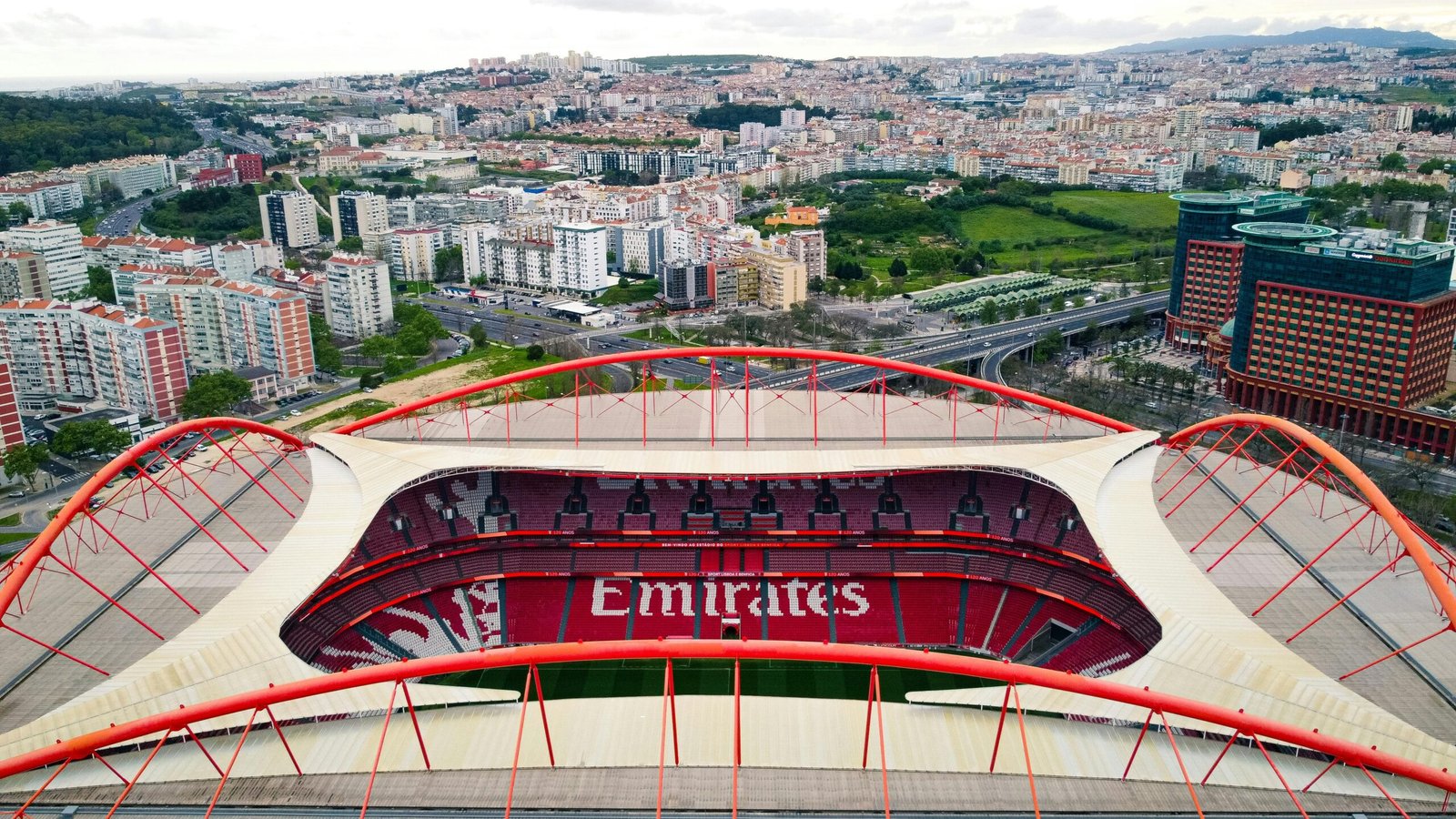 Aerial shot of Estádio da Luz stadium with Lisbon cityscape backdrop in Portugal.
